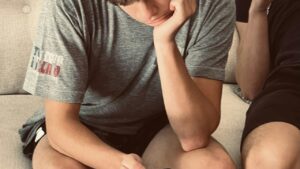 Adolescente sentado no sofá olhando o celular