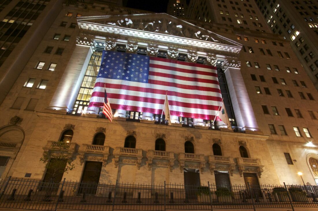 Fachada da Bolsa de Valores de Nova York com uma grande bandeira dos Estados Unidos Fachada da Bolsa de Valores de Nova York com uma grande bandeira dos Estados Unidos