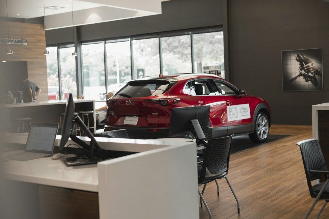 Carro vermelho novo exposto no showroom de uma concessionária