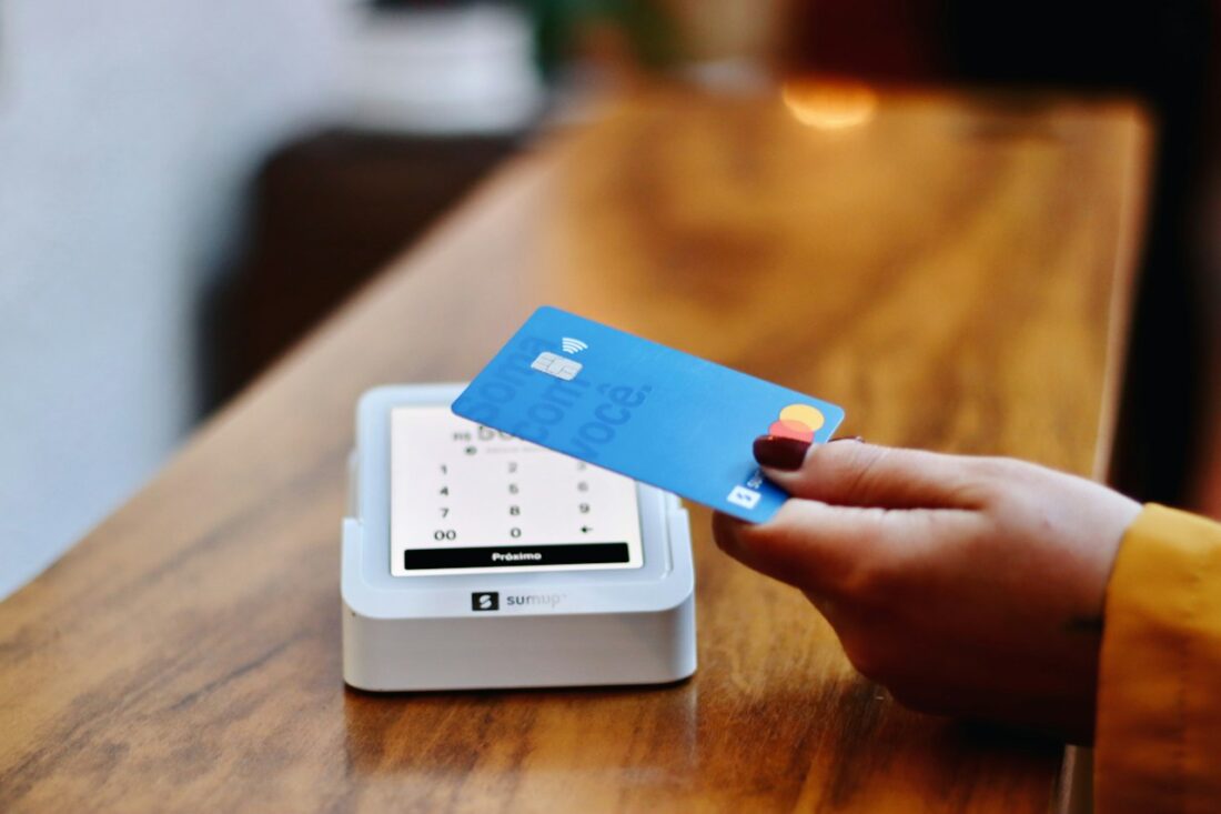 Cliente aproximando o cartão de uma maquininha para pagar por aproximação