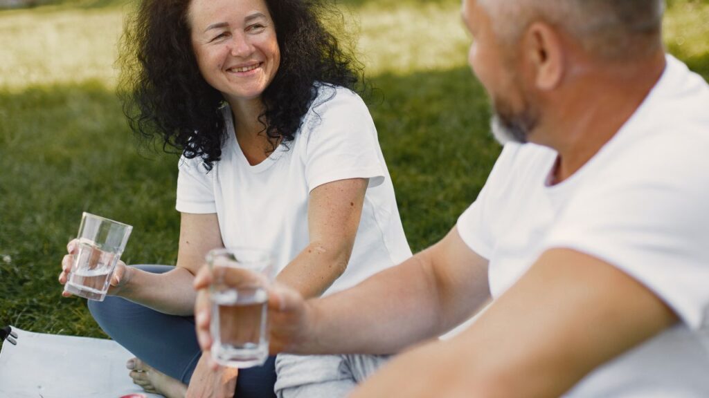 Mulher morena sorrindo durante um piquenique a dois no campo Mulher morena sorrindo durante um piquenique a dois no campo