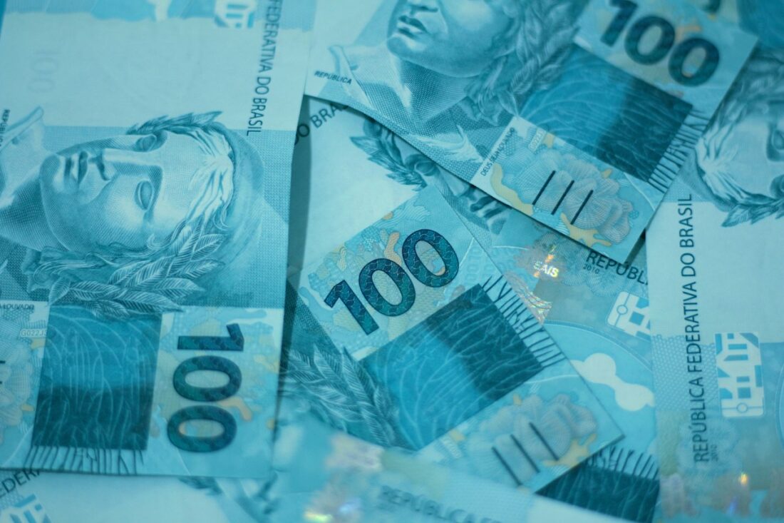 Pilha de notas de cem reais sobre a mesa